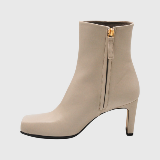 Beige kantig tå skinnstövlett. Hållbara square toe ankle boots även kallade fyrkantig tå stövlett från sidan med dolddragkedja på innersidan. Guld dragare och beige napaskinn med skinnkläddklack. Vero cuoio sulan skymtas  vid hälen och klacken.  Svart giftfri gummisula framtill.